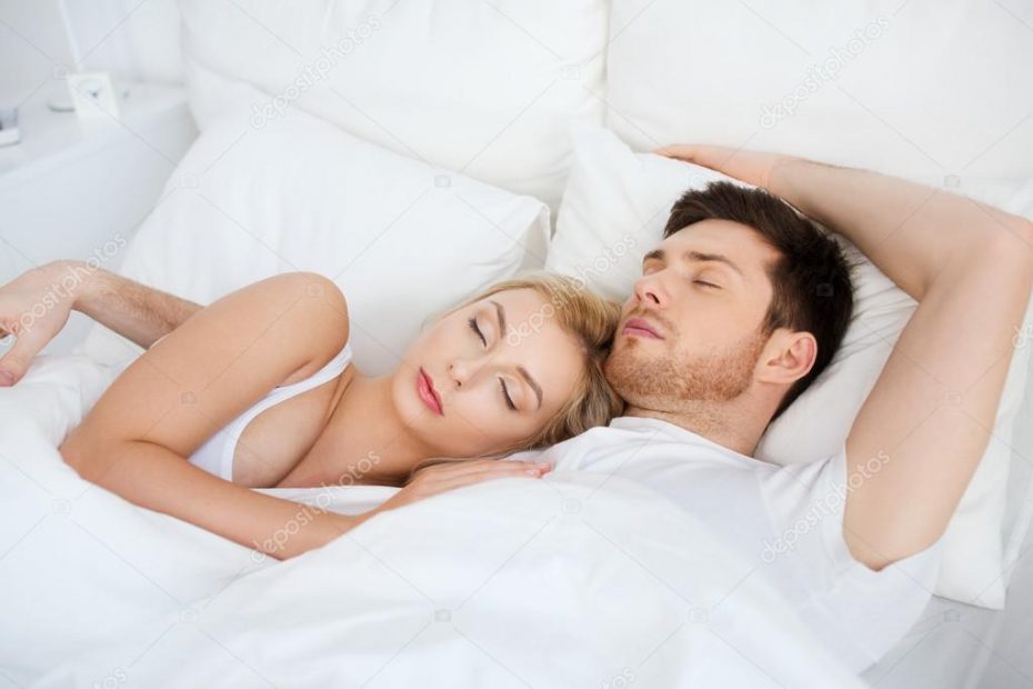 pareja durmiendo en cama blanca